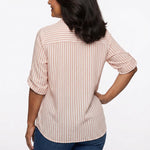 Back view of a woman in a pink and white vertical stripe roll-tab 3/4 sleeve button-front blouse paired with dark blue jeans.