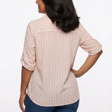 Back view of a woman in a pink and white vertical stripe roll-tab 3/4 sleeve button-front blouse paired with dark blue jeans.