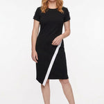 Front view of a black short-sleeve sheath dress with white diagonal stripe and asymmetric hem, button shoulder detail, worn