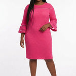Plus-size model wears a fuchsia textured sheath dress with sheer stripe accents at the chest and flared bell sleeves, front