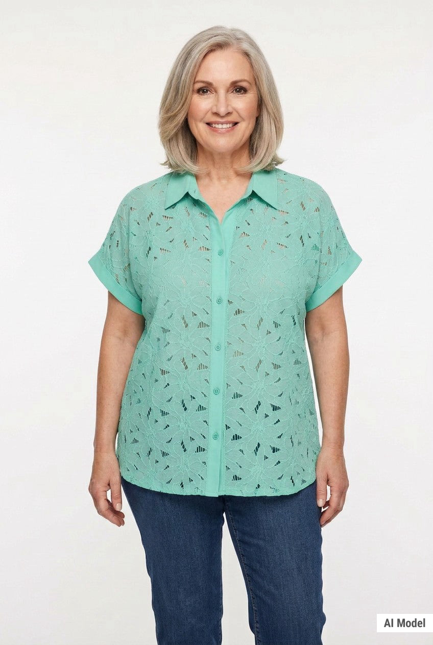 Older woman with gray bob wearing a mint green short-sleeve lace eyelet button-front blouse with collar, paired with blue
