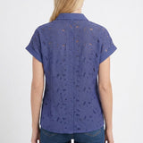 Blonde female model shown from back wearing a patriot blue short-sleeve eyelet button-back blouse with cuffed sleeves,