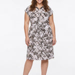 Plus-size model wears a knee-length geometric print shirtdress with collar, cap sleeves, and self-tie belt, front view.