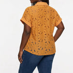 Plus-size model with box braids wears a mustard yellow short-sleeve eyelet collared blouse with cuffed sleeves, back view,