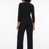 Black 3/4-sleeve wide-leg belted jumpsuit with elastic waist shown from the back on a woman wearing strappy heels.