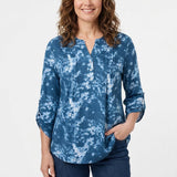 Woman wearing a blue tie-dye popover top with Y-neckline, pintucks, button placket, and roll-tab 3/4 sleeves; front view,