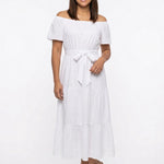 White off-shoulder short-sleeve tiered maxi dress with tie belt; front view on a dark-haired woman wearing nude strappy