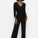 Black wide-leg jumpsuit with V-neck wrap bodice, 3/4 sleeves, and self-tie waist belt; female model, front view, full length.