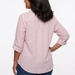 Back view of a woman wearing a pink and white vertical-stripe roll-tab 3/4-sleeve blouse with back yoke, paired with dark