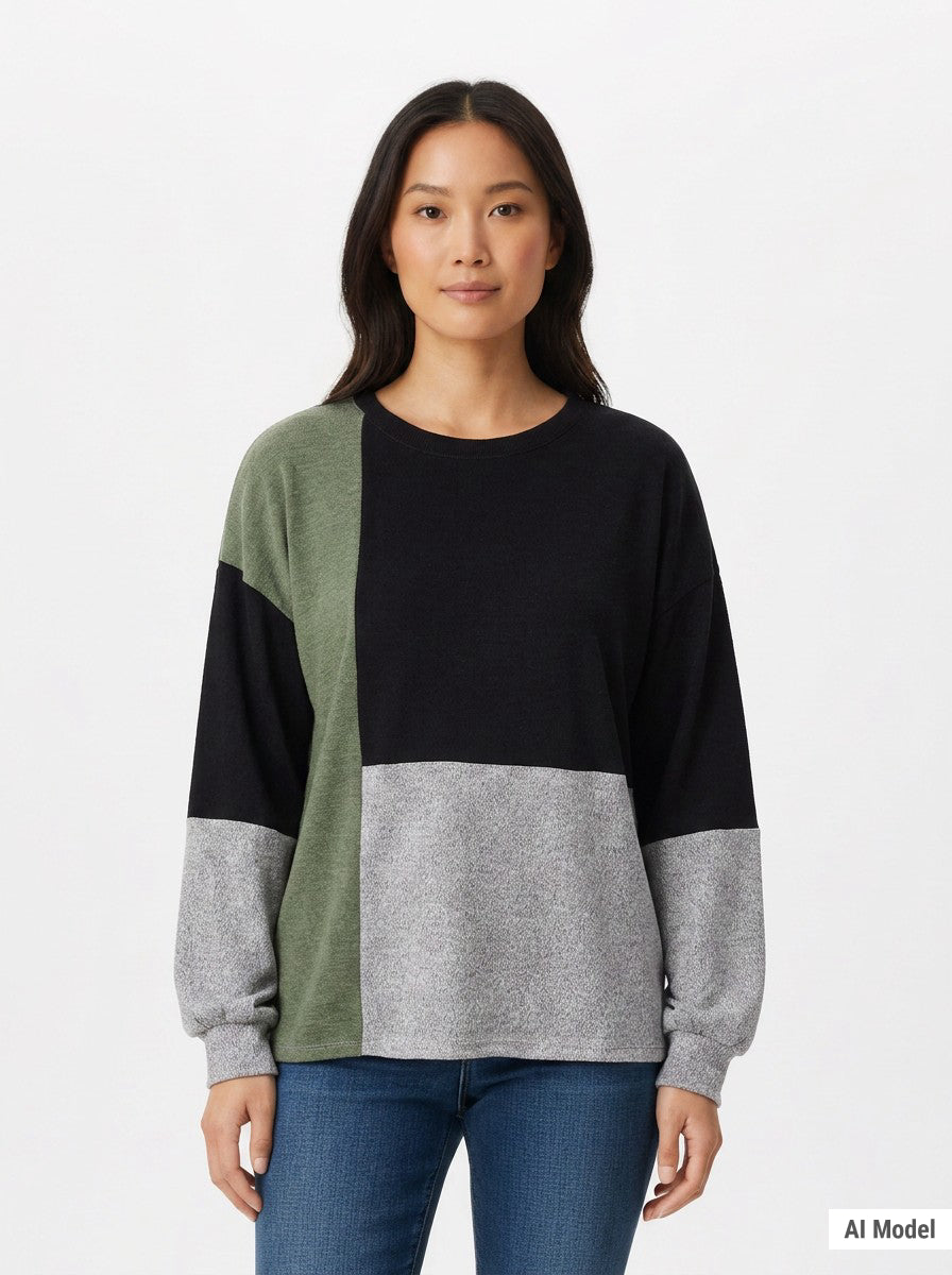 Woman wearing a color-blocked pullover in black, sage green, and heather gray with a crewneck and long sleeves; front view,