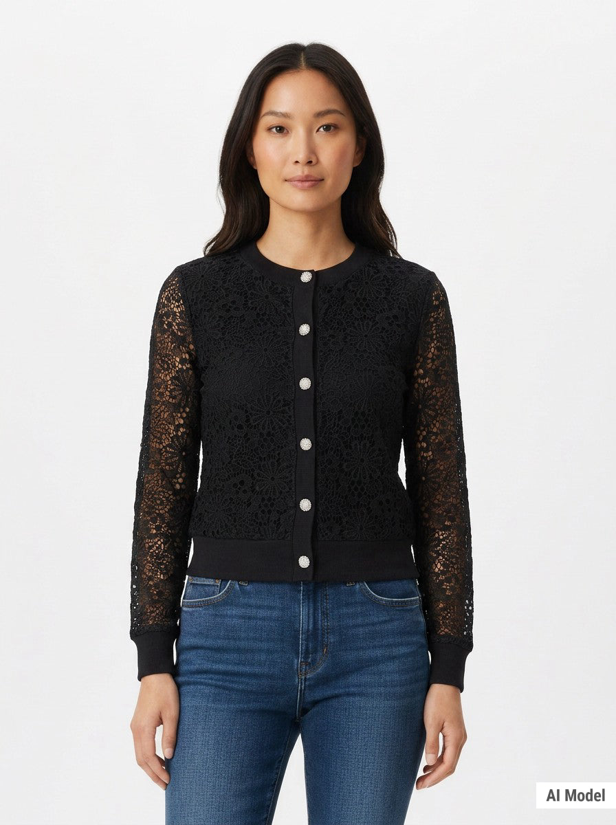 Woman wearing a black floral lace cardigan with sheer sleeves, jewel buttons, and ribbed trim, paired with blue jeans; front