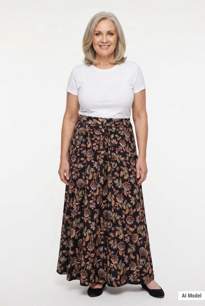 Black floral-print knit maxi skirt with sash waist tie, worn by a gray-haired woman with a white tee; full front view.