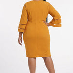 Plus-size model wears a mustard yellow textured sheath dress with 3/4 bell sleeves featuring sheer stripe panels, back view.