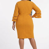 Plus-size model wears a mustard yellow textured sheath dress with 3/4 bell sleeves featuring sheer stripe panels, back view.