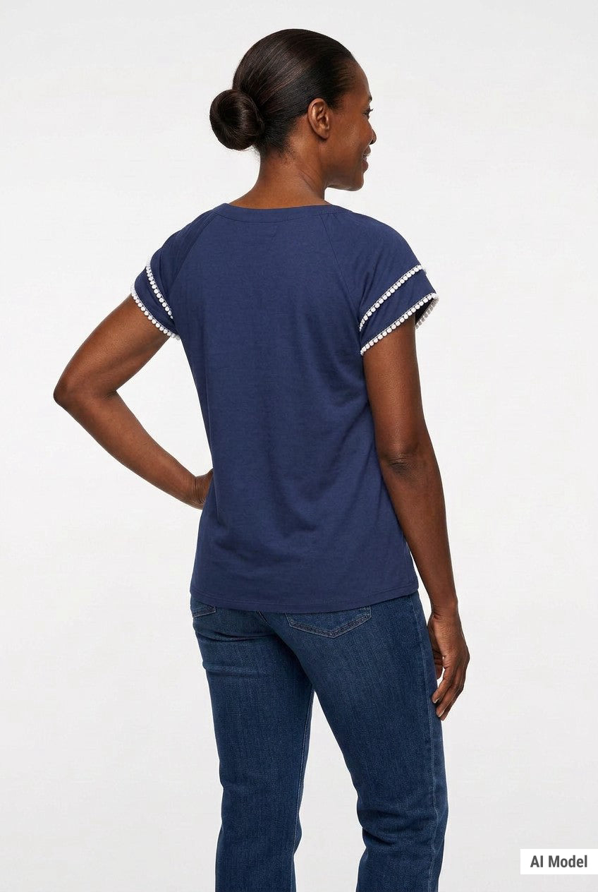 Navy blue short-sleeve top with white pom-pom trim on layered flutter sleeves, worn with dark jeans; back view of a Black