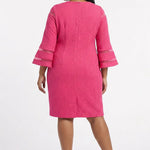 Plus-size model wears a hot pink textured sheath dress with 3/4 bell sleeves featuring sheer stripe trim; back view, knee