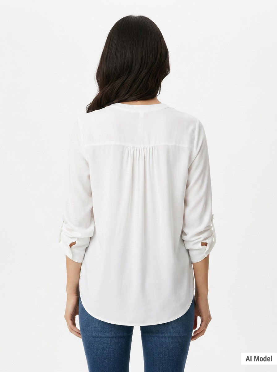 Back view of a woman wearing an ivory long-sleeve blouse with tab sleeves, back yoke pintuck detail, and a curved hem,