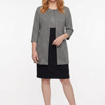 Black-and-white houndstooth 3/4-sleeve jacket over a black knee-length sheath dress, worn by a redheaded woman, front view.