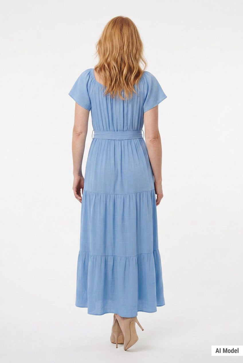 Light blue short-sleeve tiered maxi dress with waist tie belt, shown from the back on a woman with red wavy hair wearing