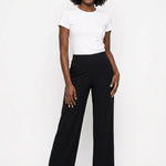 Black wide-leg pull-on palazzo pants with smooth elastic waist, worn by a Black woman, front view, paired with white tee and
