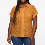 Plus-size model wears a golden orange short-sleeve eyelet button-front blouse with floral cutwork and cuffed sleeves; front