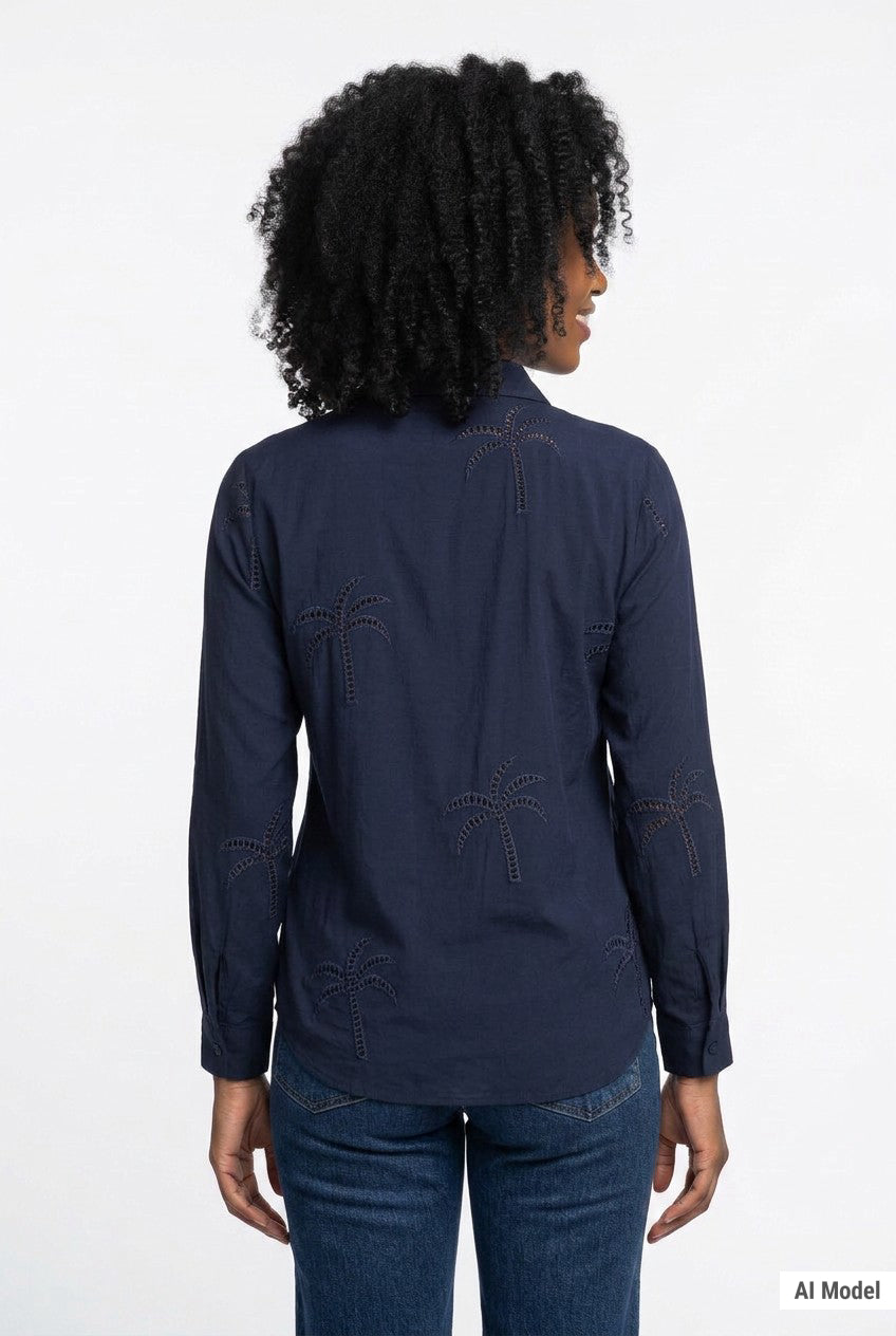 Woman wearing a navy long-sleeve button-front blouse with tonal palm tree eyelet embroidery, shown from the back, paired