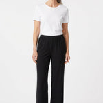 Black pull-on pants with elastic waistband and wide-leg silhouette on a gray-haired woman, front view, full length.