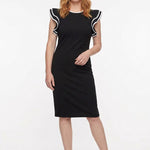 Black knee-length sheath dress with flutter sleeves and white contrast tipping at neckline and sleeve edges, worn by a