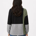 Back view of a women's color-blocked pullover top in black, heather grey, and sage green on a dark-haired female model