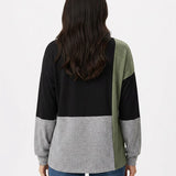 Back view of a women's color-blocked pullover top in black, heather grey, and sage green on a dark-haired female model