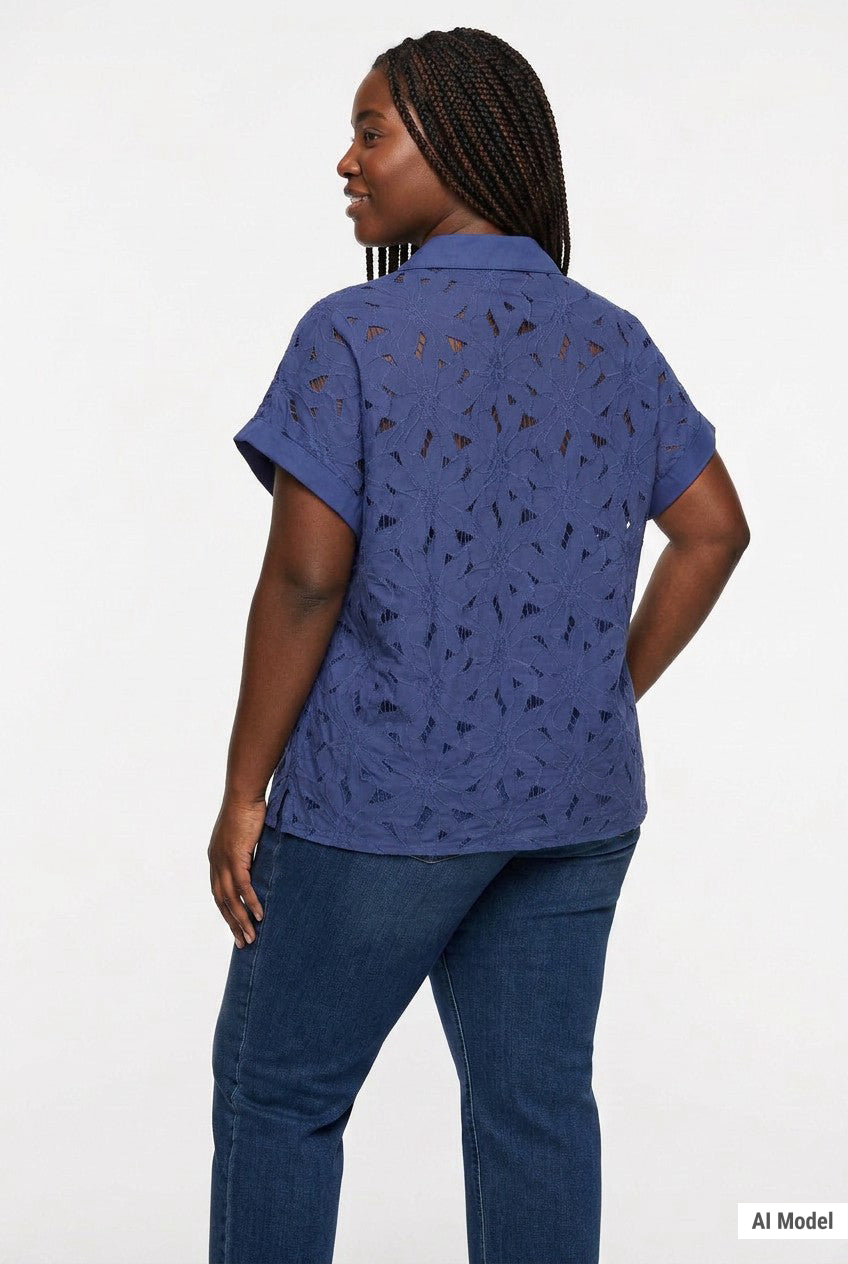 Back view of a plus-size model wearing a navy blue short-sleeve eyelet button-front blouse with floral cutwork detail,