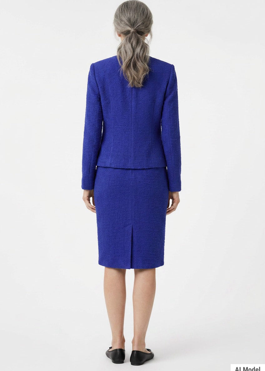 Back view of a woman with gray hair wearing a royal blue textured knit jacket and knee-length pencil skirt set with a back