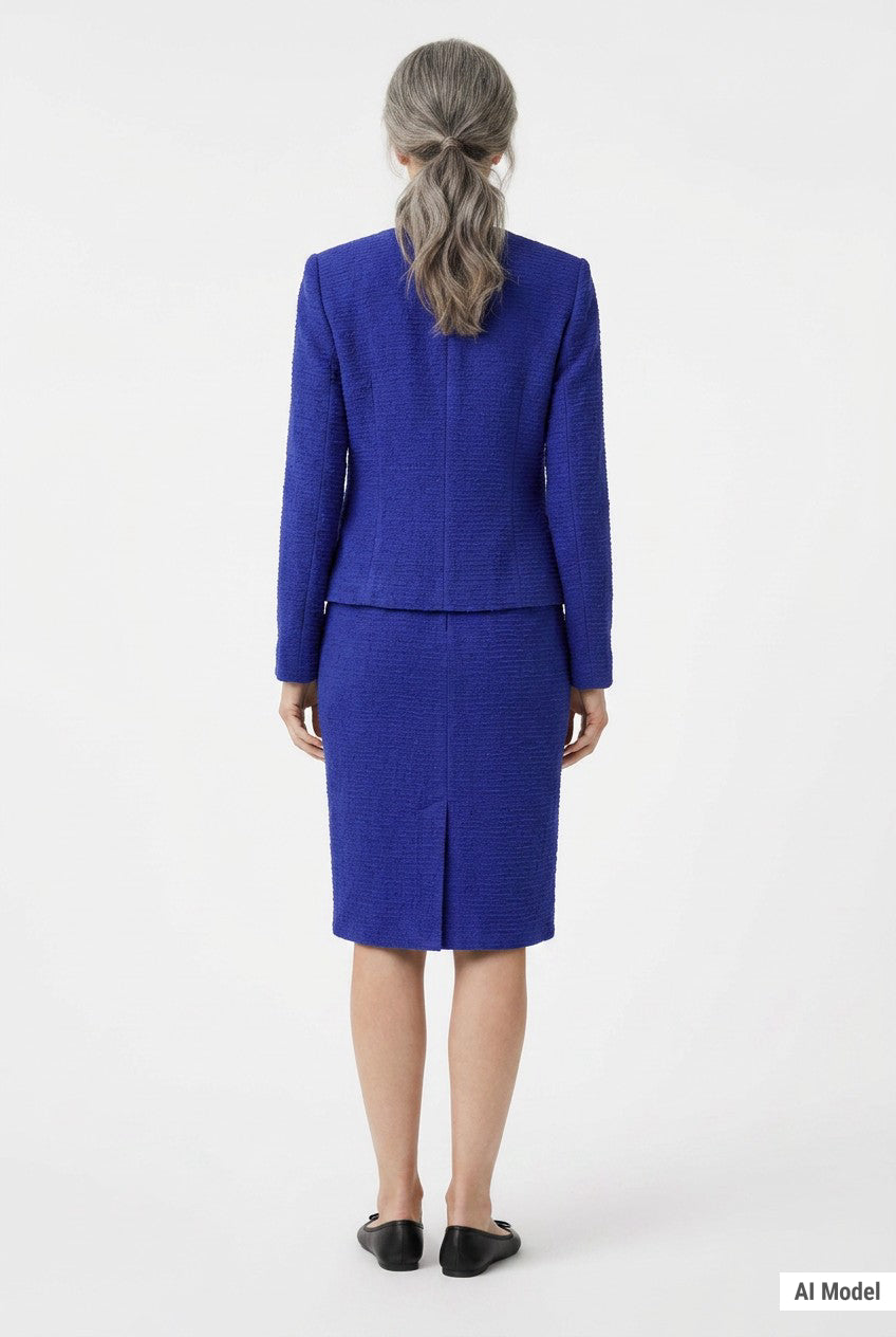Back view of a woman with gray hair wearing a royal blue textured knit jacket and knee-length pencil skirt set with a back