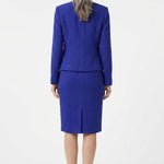 Back view of a woman with gray hair wearing a royal blue textured knit jacket and knee-length pencil skirt set with a back