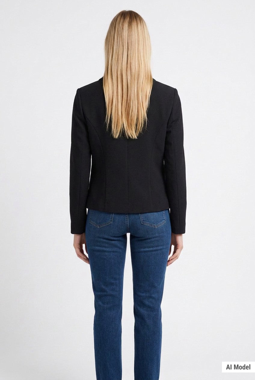 Back view of a blonde woman wearing a black cropped long-sleeve crepe jacket with seam detailing, paired with blue jeans.