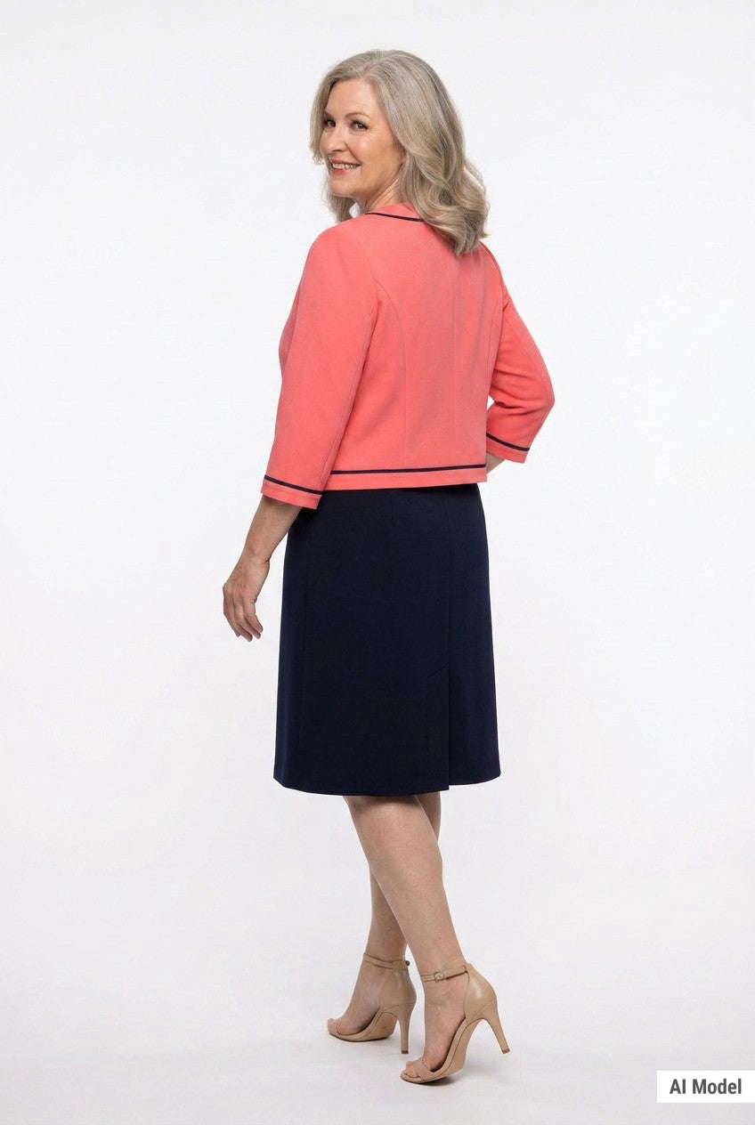 Plus-size model shown from back wearing a coral 3/4-sleeve cropped jacket with navy trim over a navy knee-length A-line