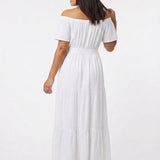 White off-the-shoulder tiered maxi dress with short sleeves and tie belt; dark-haired woman shown from behind, back view.