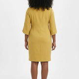Woman wearing a mustard yellow sheath dress with 3/4 petal sleeves trimmed with pearl details; back view, knee length.