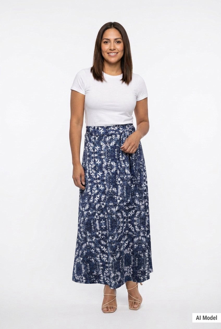 Navy and white paisley-print knit maxi skirt with sash waist tie, worn by a brunette woman, full front view.