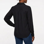 Black long-sleeve satin blouse with puff shoulders, back yoke with gathers, and button cuffs, on a woman with a bun, rear