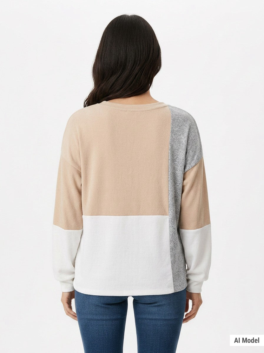 Woman's back view wearing NY Collection colorblock pullover in beige, grey, and white panels with long sleeves, paired with