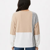 Woman's back view wearing NY Collection colorblock pullover in beige, grey, and white panels with long sleeves, paired with