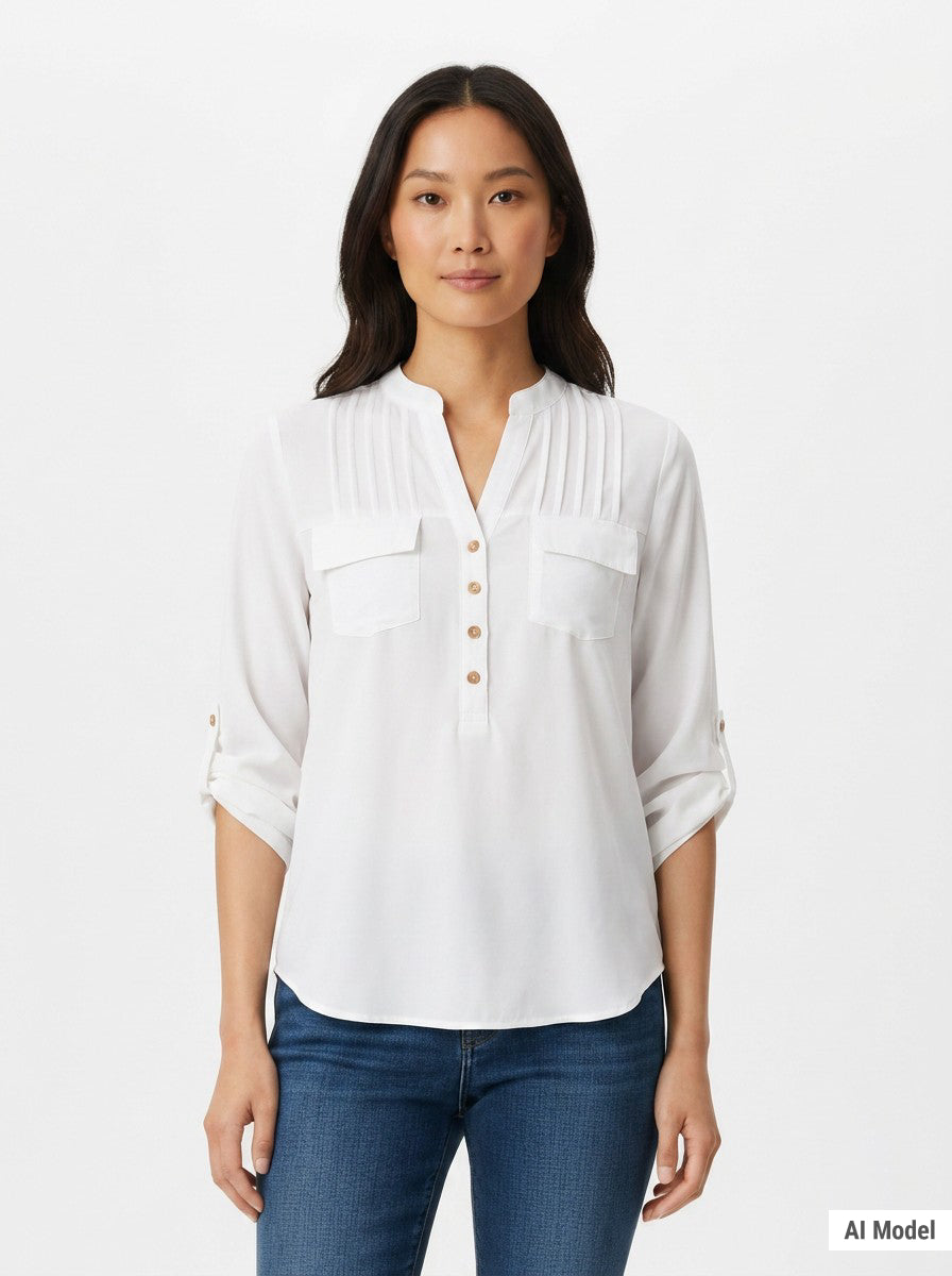 Woman wearing a white popover blouse with pintuck yoke, dual chest pockets, roll-tab sleeves, and tan buttons; front view,