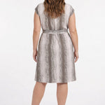 Plus-size model shown from back wearing a sleeveless belted knee-length dress in taupe snake print with a self-tie waist