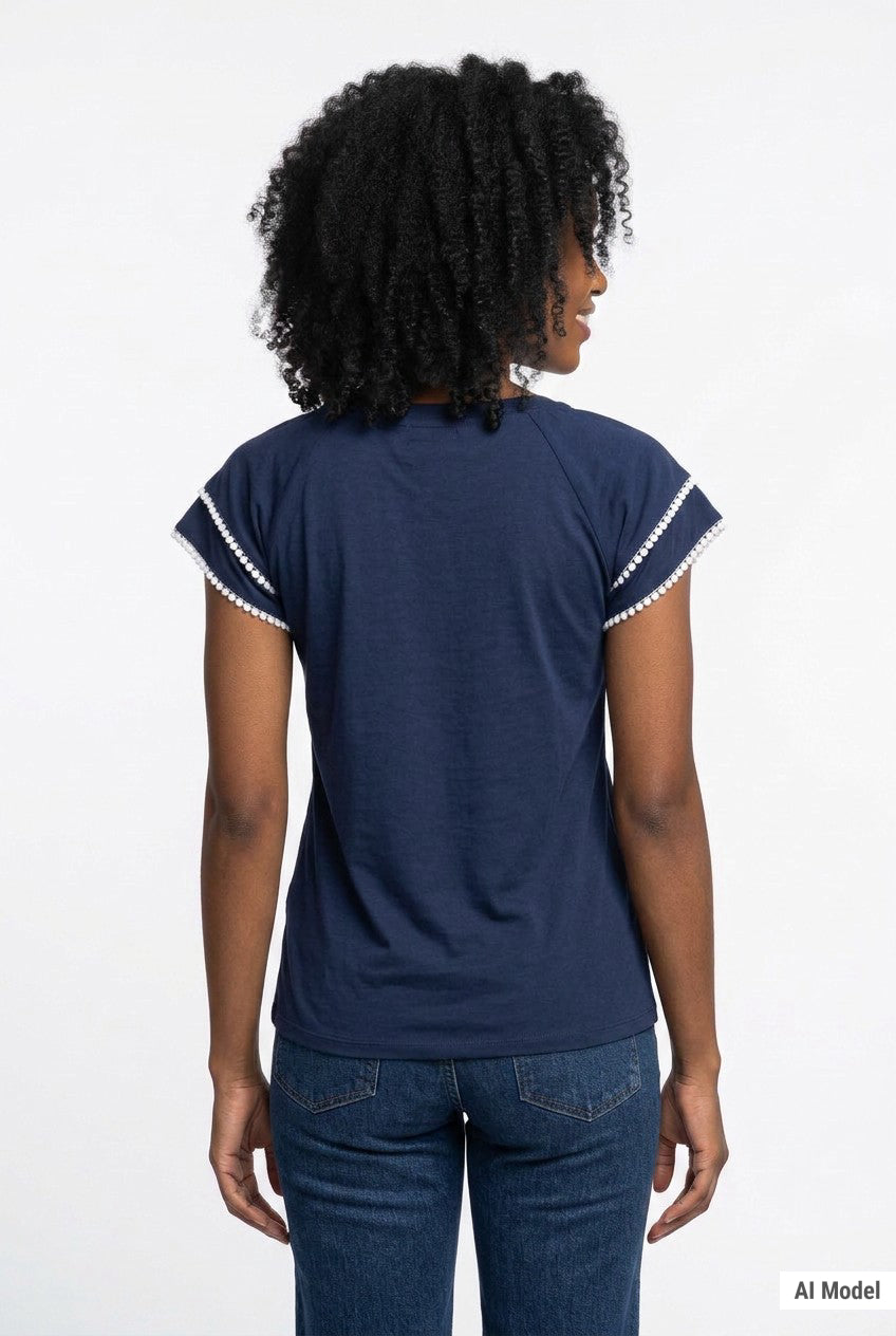 Back view of a woman wearing a navy blue double-layer V-neck blouse with white pom-pom trim on flutter sleeves, paired with