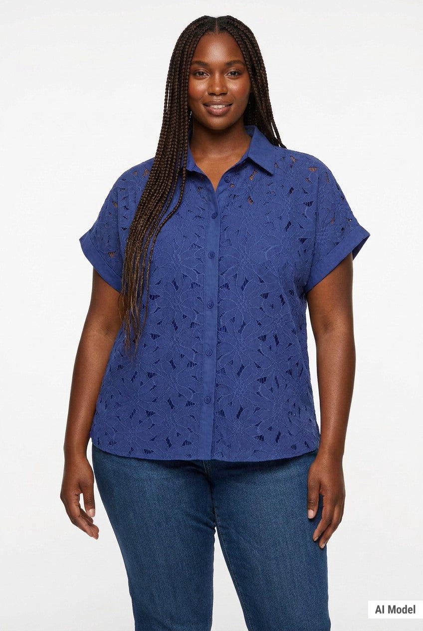 Plus-size model wears a navy blue short-sleeve eyelet button-front blouse with floral cutwork pattern; front view, waist up.