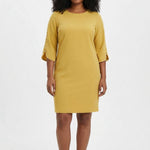 Plus-size model wears a mustard yellow sheath dress with 3/4 petal sleeves trimmed with pearl details and a round neckline,