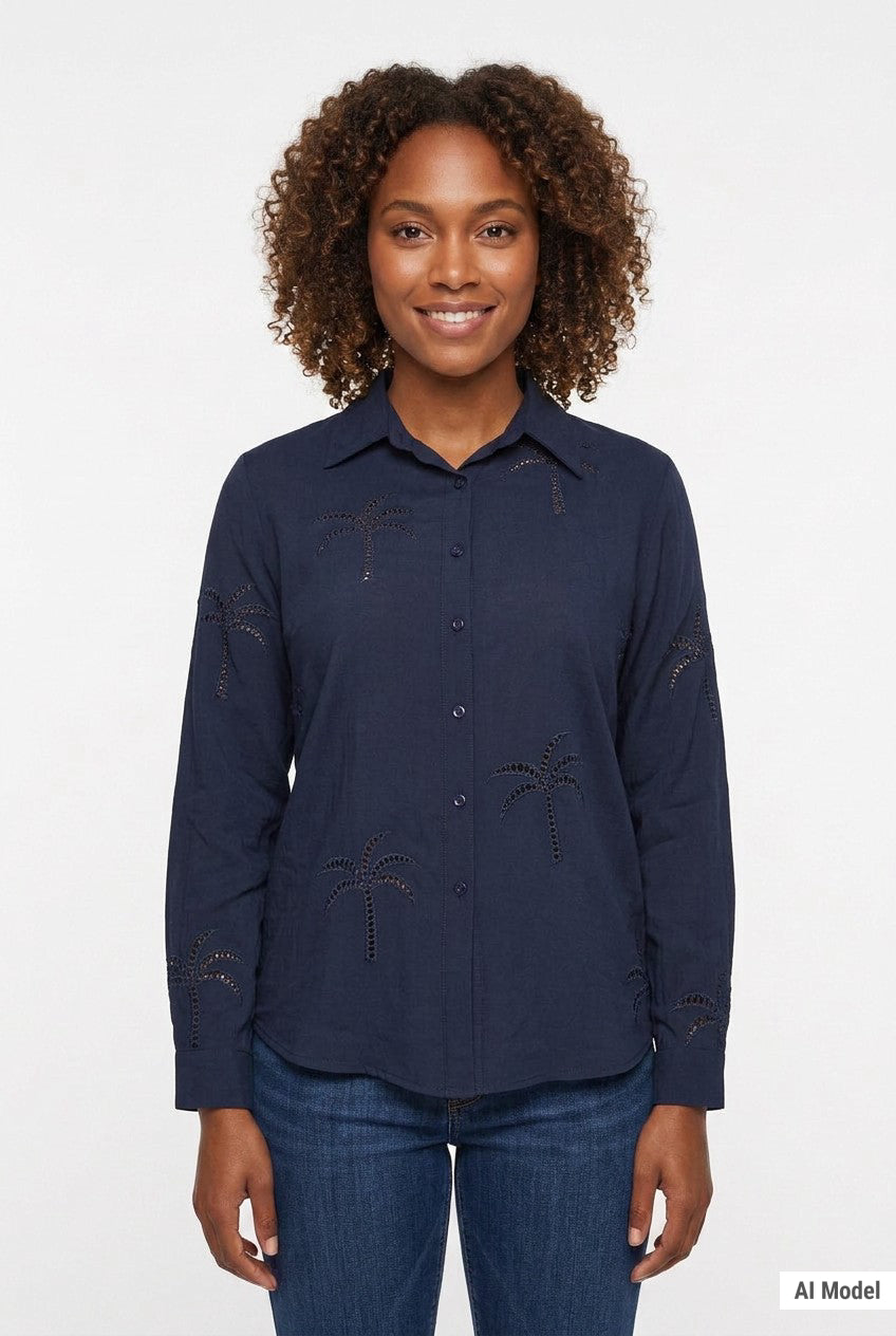 Navy long-sleeve button-front blouse with cutwork palm tree embroidery, worn by a curly-haired woman, front view, waist up.