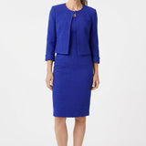 Older woman with gray hair wearing a royal blue textured knit 2-piece dress set with cropped 3/4-sleeve jacket and