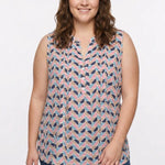 Plus-size model wears a sleeveless pintucked blouse in a multicolor half-moon geometric print with a split neckline and